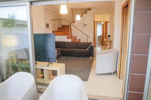 a living room with a couch and a table at Casas e Quintas de Praia in Praia da Barra