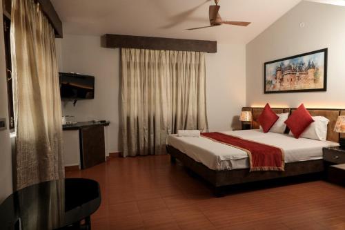 1 dormitorio con 1 cama grande con almohadas rojas en Sao Domingos, en Cavelossim