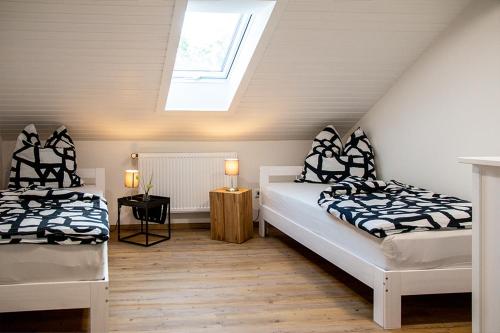 a attic bedroom with two beds and a skylight at Auszeit Bischberg bei Bamberg für Urlauber in Bischberg