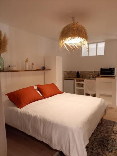 - une chambre avec un grand lit blanc et un lustre dans l'établissement AGREABLE STUDIO VUE PORT AU CAP D'AGDE, au Cap d'Agde
