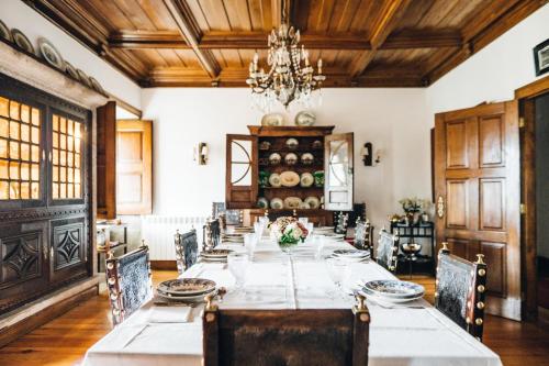 a dining room with a long table with chairs and a chandelier at Quinta De Guimaraes in Miguas