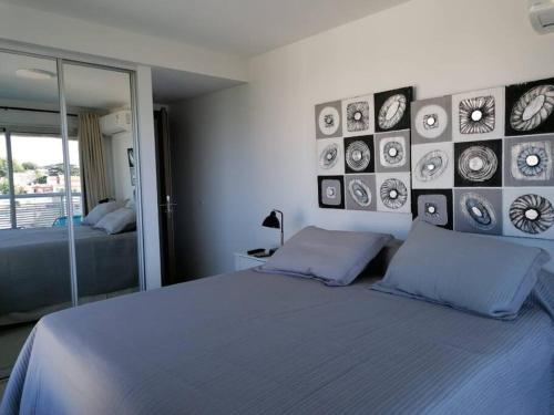 Un dormitorio con una cama azul con cuadros en la pared en Solares de Araus 406, en Colonia del Sacramento