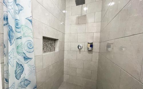 baño con ducha y puerta de cristal en Departamentos DOS21, en Mazatlán