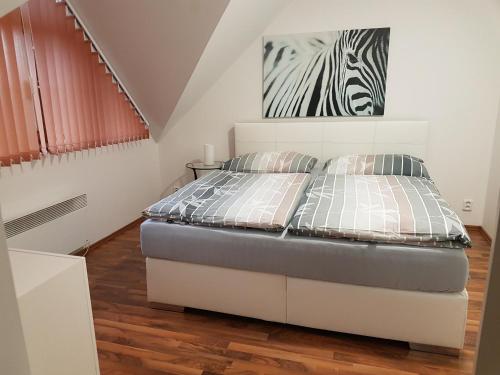 a bedroom with a bed and a zebra picture on the wall at Apartmán V aleji in Slavkov u Brna