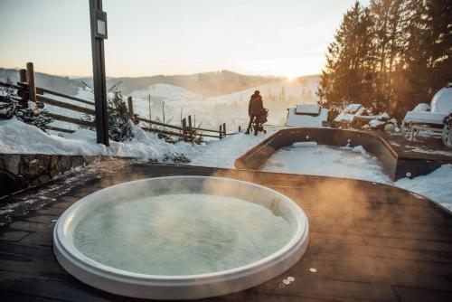 a jacuzzi tub with a person in the snow at Stara Pravda Hotel in Bukovel