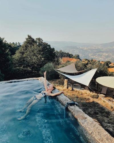 a woman laying in a pool of water at Family Room - Quinta do Mirante in Castelo de Paiva