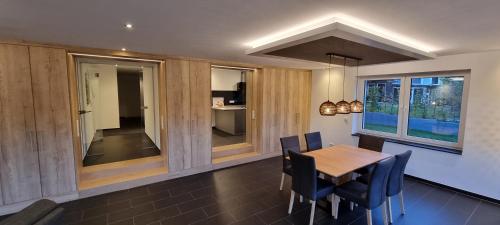 een eetkamer met een houten tafel en stoelen bij Upland Lounge in Willingen