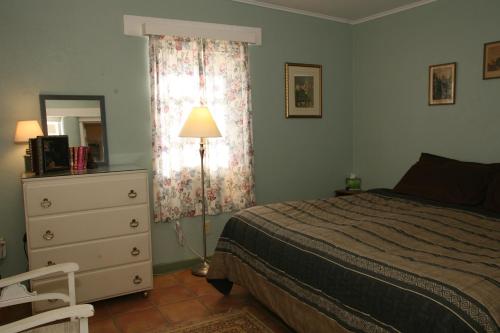 a bedroom with a bed and a dresser and a lamp at Spirit Tree Inn B&B in Patagonia