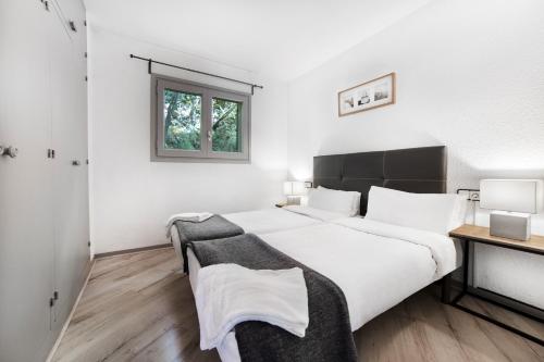 een slaapkamer met 2 bedden, een bureau en een raam bij Avet in El Tarter
