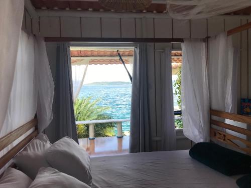 a bedroom with a bed with a view of the ocean at Cabana do Mar in Angra dos Reis