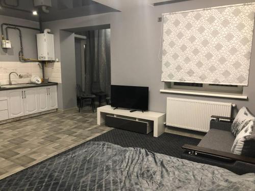 a living room with a couch and a tv at Аpartments Central Town Містечко Центральне з власним паркінгом та документами на проживання in Ivano-Frankivsʼk