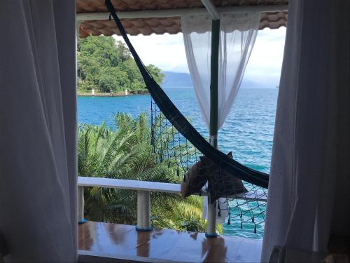 a hammock on a balcony overlooking the ocean at Cabana do Mar in Angra dos Reis