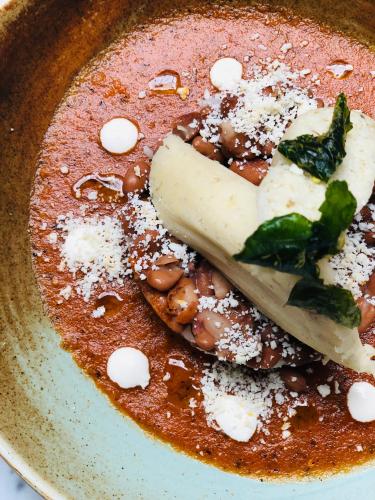 a bowl of chili with beans and cheese and a spoon at Hotel Herencia By Hosting House in Morelia