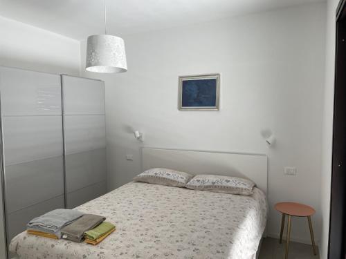 GainoにあるLa Casettaの白いベッドルーム(ベッド1台、テーブル付)