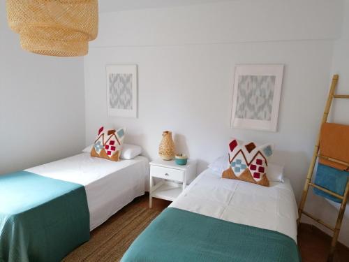 two beds in a room with white walls at Beach Front Las Burras in San Agustin