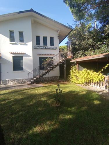uma casa branca com uma escada no quintal em Villa Pineta em Milano Marittima