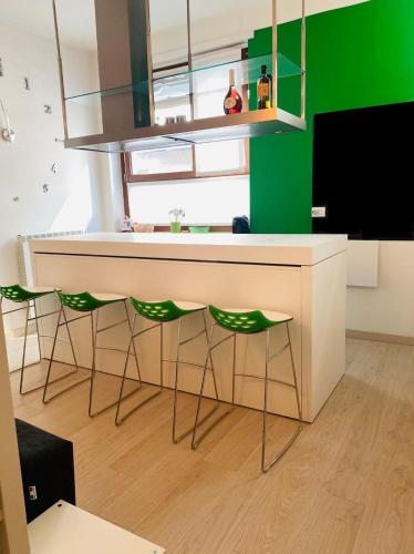 kuchnia z biurkiem i 2 zielonymi krzesłami w obiekcie TORINO CENTRO - La Casa Di Zoe w Turynie