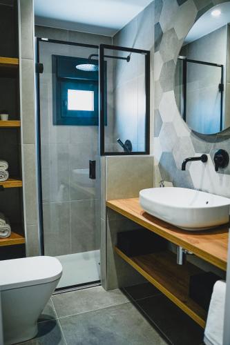 a bathroom with a sink and a shower and a toilet at Apartamentos Turia Teruel in Teruel