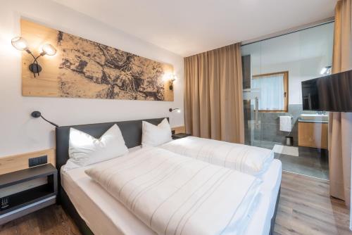 a hotel room with two beds and a tv at CHALET NORA in San Vigilio Di Marebbe