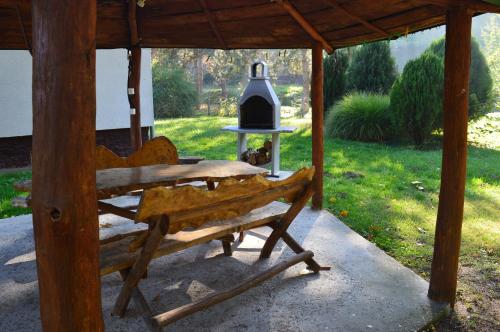 a wooden bench under a gazebo with a bell at Bogoljubova vinska koliba in Vrdnik
