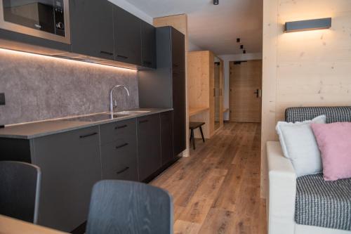 a kitchen and living room with a sink and a couch at CHALET NORA in San Vigilio Di Marebbe