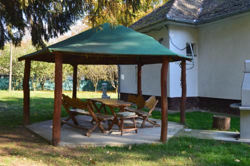 a gazebo with two chairs and a table in a yard at Bogoljubova vinska koliba in Vrdnik