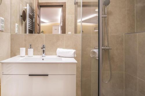 een badkamer met een wastafel en een douche bij Spa Residence Carbona Apartment 205 in Hévíz