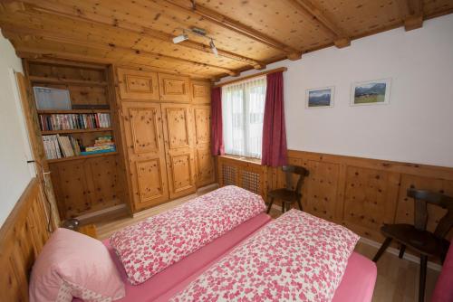 ein Schlafzimmer mit einem Bett und einem Bücherregal in der Unterkunft Ferienwohnung Steinmann in Scuol