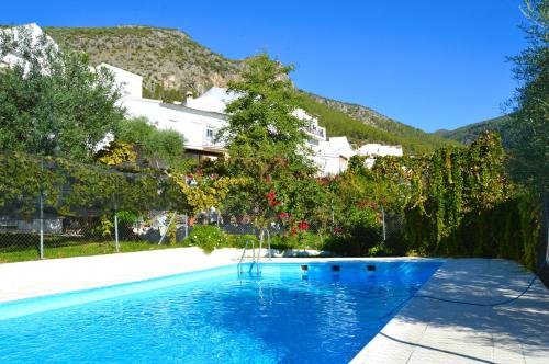 a swimming pool with blue water in front of a building at EcoAlbergue Rural de Algodonales in Algodonales