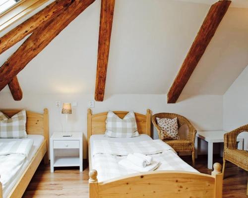 two beds in a room with wooden beams at Garni Hotel St Anna in Boží Dar