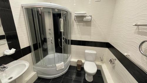 a bathroom with a toilet, sink, and bathtub at Vista Hotel in Krasnodar