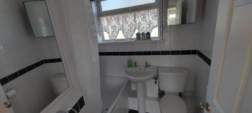 baño con aseo y lavabo y ventana en Rosa Blanca en Sandown