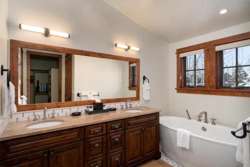 a bathroom with two sinks and a tub and a large mirror at The Porches in Steamboat Springs