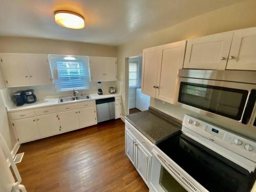 a kitchen with white cabinets and a sink and a microwave at Charming 2 BR 1 BA with outdoor patio and grill close to downtown in Lexington