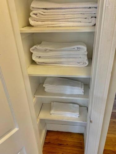 a closet filled with white towels and towels at Charming 2 BR 1 BA with outdoor patio and grill close to downtown in Lexington
