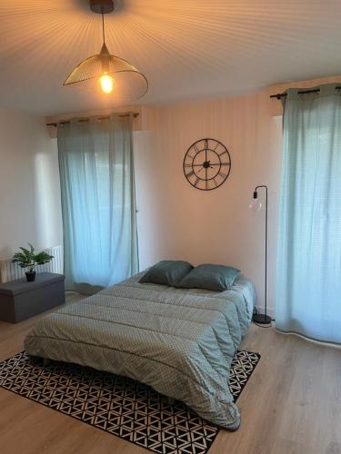 a bedroom with a bed and a clock on the wall at Grand studio Clémenceau Vue mer 3 étoiles in Pléneuf-Val-André