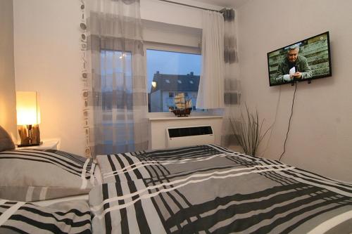 a bedroom with a bed and a tv on a wall at Haus Möwe Wohnung Leuchttürmchen in Hörnum