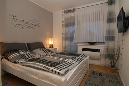 a bedroom with a bed and a window at Haus Möwe Wohnung Leuchttürmchen in Hörnum