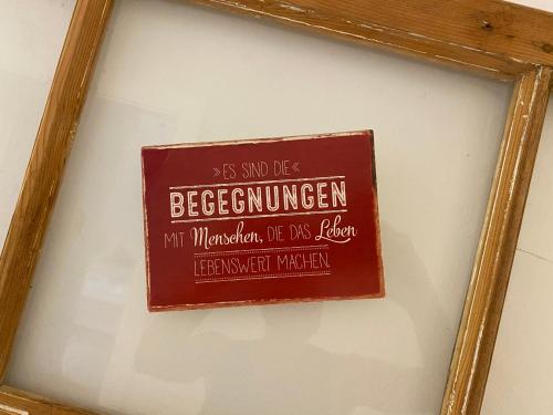 a sign in a frame hanging on a wall at Hotel Garni Vinea Montis in Termeno