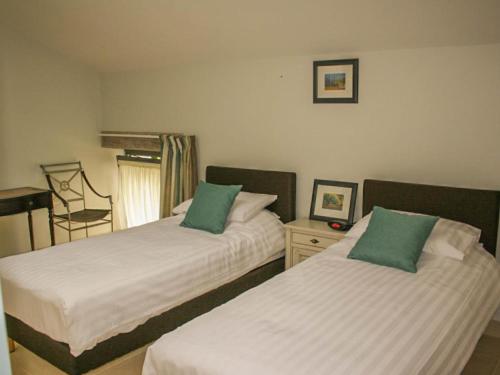 a bedroom with two beds with green pillows at Gite La Séoune in Monjoi