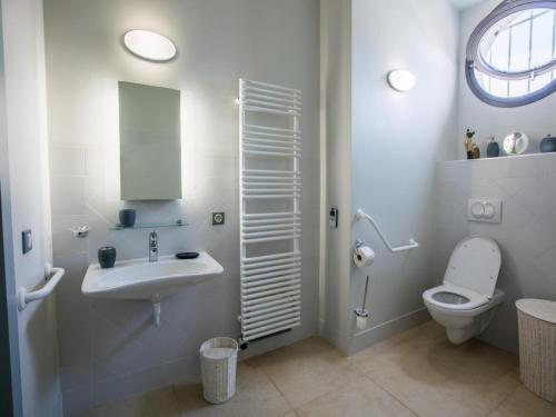 a white bathroom with a sink and a toilet at Gite La Séoune in Monjoi