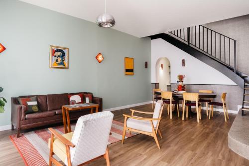 uma sala de estar com um sofá, uma mesa e cadeiras em Edgar Suites Notre-Dame - Lagrange em Paris