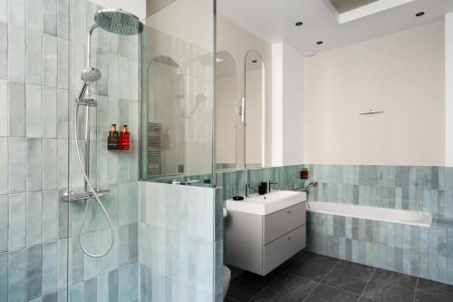 a bathroom with a sink and a shower at Edgar Suites Notre-Dame - Lagrange in Paris