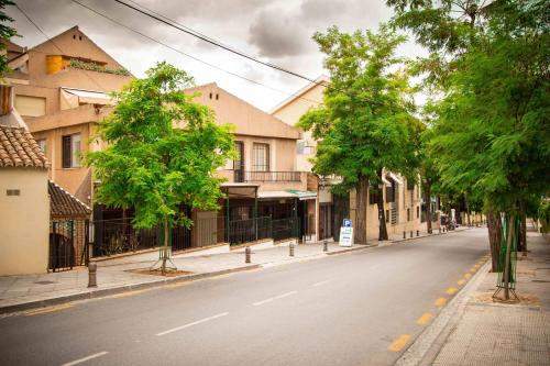 an empty street with trees on the side of the road at Hostal Bocanegra in Granada