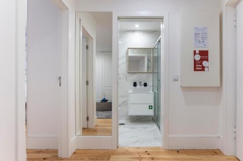 een hal met een deur naar een badkamer bij Elegant Downtown 1BR Flat w/ AC by LovelyStay in Porto