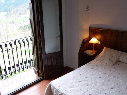 a bedroom with a bed and a large window at Casa Mur A in Foradada de Toscar