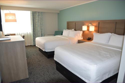 a hotel room with two beds and a desk at Fun City Resort Hotel in Burlington