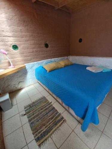 a bed in a room with a blue bedvisor at Casa Buenavista in San Pedro de Atacama