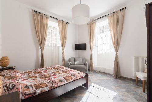 a bedroom with a bed and a chair and windows at Domus Maximo in Rome