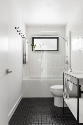 a bathroom with a tub and a toilet and a sink at Chalet du bois flotté in La Malbaie